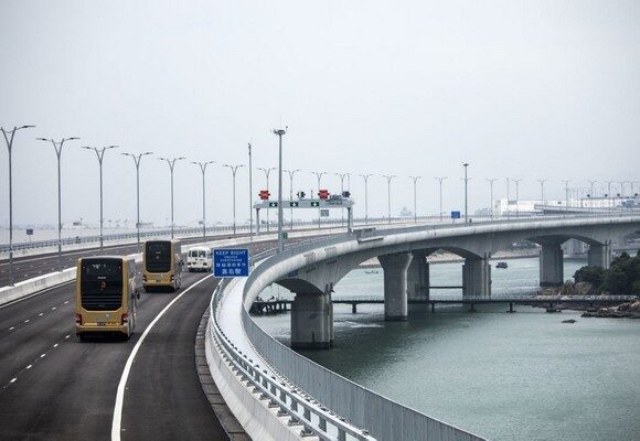 Shuttle buses travel along the Hong Kong Link Road section of the Hong Kong-Zhuhai-Macau Bridge during a media tour of the bridge offshore in Hong Kong, China, on Friday, Oct. 19, 2018. The Hong Kong-Zhuhai-Macau Bridge, scheduled to commence operations on Oct. 24, will be one of the world's longest bridges, connecting the former European outposts of Hong Kong and Macau for the first time and tying them both to southern China. Photographer: Justin Chin/Bloomberg via Getty Images