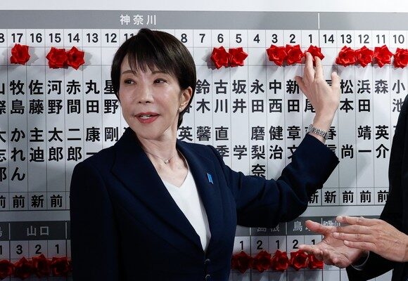 epa12716248 Japan's Prime Minister Sanae Takaichi, leader of the ruling Liberal Democratic Party (LDP), places a red paper rose on the name of an elected candidate at the LDP headquarters on general election day in Tokyo, Japan, February 8, 2026.  EPA/Kim Kyung-Hoon / POOL