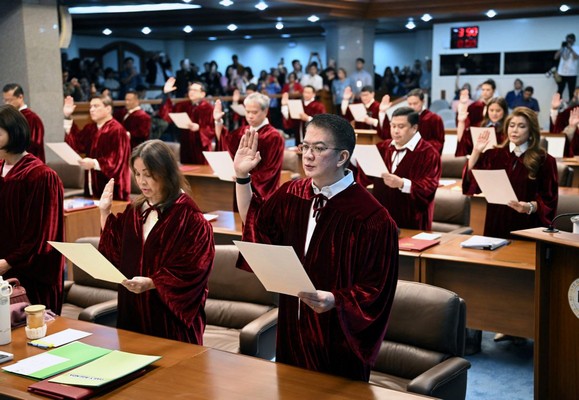 Philippine senators take their oath as jurors in the impeachment trial of Vice President Sara Duterte at the plenary hall of the Senate in Manila on May 18, 2026. Philippine lawmakers were sworn in on May 18 to serve as judges in the trial of impeached Vice President Sara Duterte, the second attempt since last year to force her from office. (Photo by Ted ALJIBE / AFP)